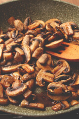 fried mushrooms in a frying pan, with a wooden fork, homemade, no people,