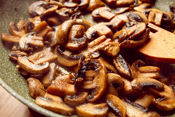 fried mushrooms in a frying pan, with a wooden fork, homemade, no people,
