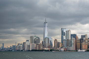 Fototapeta premium New York, NY, USA - August 4, 2023: Manhattan skyline N of Battery Park under gray intimidating cloudscape, seen from the SW