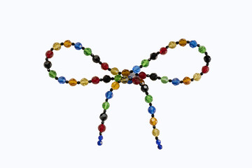 Ribbon bow made of colorful beads isolated displays rhinestone facets that sparkle. The pattern suggests tying a package with a knot or a bow.