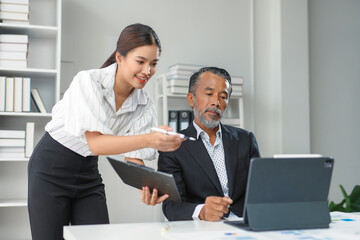 Business team analyzing financial charts and graphs on digital tablet and laptop computer in modern office
