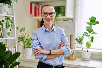 Portrait of confident smiling middle-aged woman with crossed arms at home