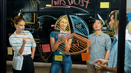 Skilled male leader explain statistic graph to expert investors. Smart businessman presenting, shows financial plans expert to investors on glass wall at night office. Business concept. Tracery