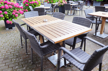 empty tables among hydrangea bushes in cafes on city streets