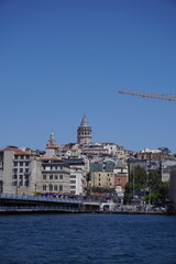 Obraz premium Vertical Galata Tower view taken behind buildings and Marmara Sea.Galata Tower background, view Istanbul.