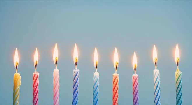 colorful holiday candles are burning, standing in a row on a blue background.