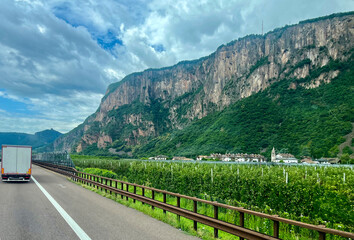 Naklejka premium Vadena, Italy. Highway in the mountains with a picturesque landscape with trucks and cars