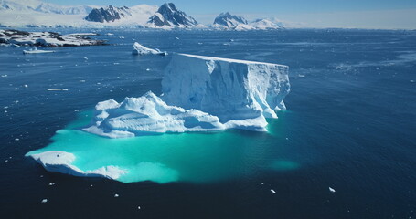 Giant iceberg towering melting blue underwater ice. Natural beauty and power. Polar winter landscape in Antarctica. Ecology, melting ice, climate change, global warming background. Aerial drone shot © mozgova