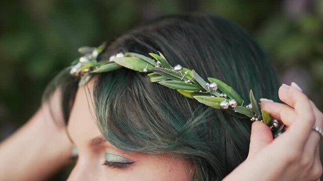 Beautiful nymph woman with dyed green hair and forest leaves crown. Cosplay wedding, elf princess in fairy tiara, fantasy make-up