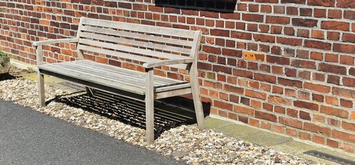 Wooden bench in front of a house with a red facade and