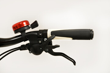 Bicycle handle bar, speed shifter, hydraulic brake handle and red ring bell isolated on total white background