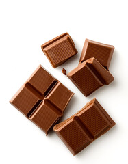 Milk chocolate pieces on a white background