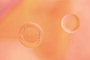 Abstract cosmetic background. Peach Fuzz abstract oil bubbles or face serum background. Oil and water bubbles macro photo