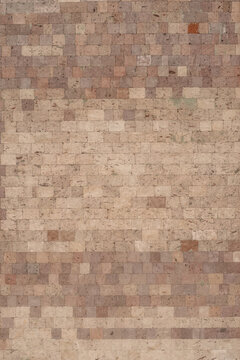 The textured wall is lined with volcanic tuff tiles of various shades.