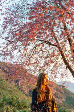 Crian&ccedil;a adolescente feliz balan&ccedil;ando debaixo da arvore no por do sol
