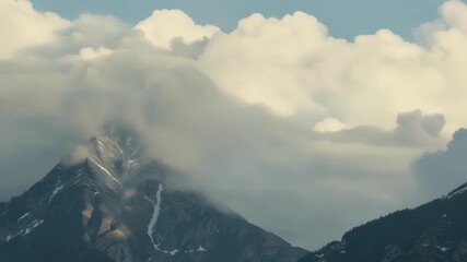 The clouds seem to play hide and seek with the mighty mountain peaks at times engulfing them completely and then revealing their splendor again.