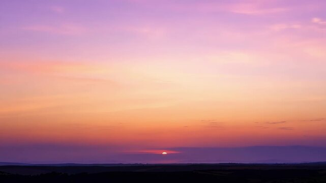 Soft pastel tones painting the sky as the sun dips towards the horizon.