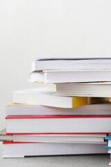 Stack of books with colorful bookbindings against white wall with copy space, book lover