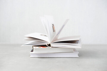 Stack of books with colorful bookbindings against white wall with copy space, Book Lover