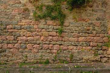 stone wall, texture, Medieval natural stone wall, pink granite, French masonry stone wall, background for photo.,moss, plants on the stone wall