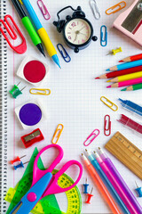 Colorful school supplies designed on a checkered notebook with copy space