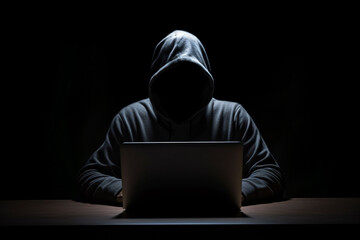 Anonymous hacker with hoodie working on computer laptop