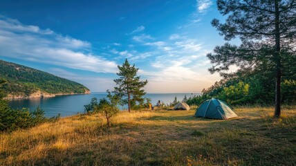 Scenic lakeside campsite with tents, trees, blue sky, and water
