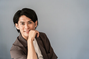 机に座る男性モデル（アイデア・考える・想像・ひらめき）
