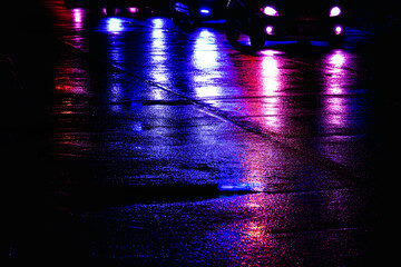A street scene with cars and a police car with its lights on. The lights are blue and purple © SAKCHAI