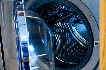 A blue and silver washing machine with the door open