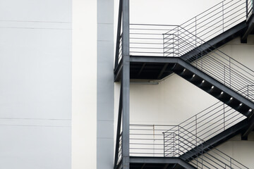 A tall building with a staircase leading up to the top. The staircase is made of metal and is very tall