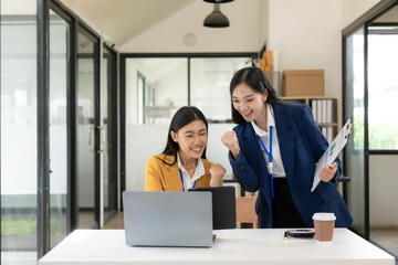 Two Asian women are checking their income by working in online sales. with laptops because sales are in line with desired targets
success
