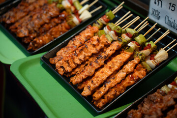 Grilled chicken skewers are ready and sell at street food market.
