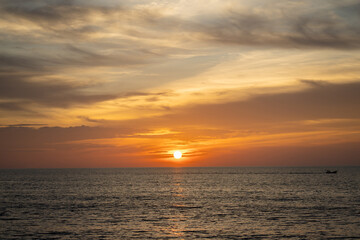 Obraz premium Landscape of sunset over the sea with a single boat.