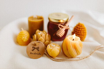 Burning candles made of natural handmade wax on a white background. Beekeeping products. Small business. Farm.