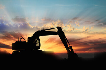 Crawler excavators silhouette are digging the soil in the construction site on the sunrise...
