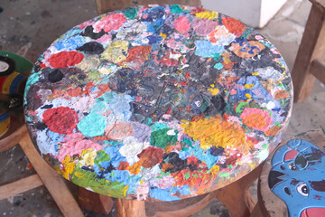 Colorful wood table with multicolored paint drops art patterns on background