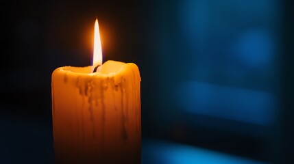 A single candle burning in the dark, with wax dripping down the side.