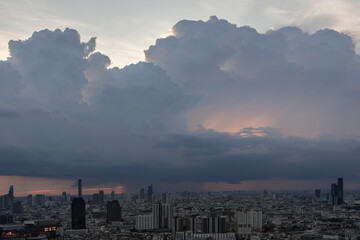 Naklejka premium Beautiful clouds in the sky over large metropolitan city of bangkok. Aerial view of skyscrapers and dramatic sky before sunset, Copy space, Selective focus.