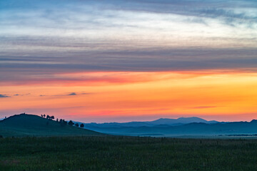 Landscape of grassland and mountain under twilight