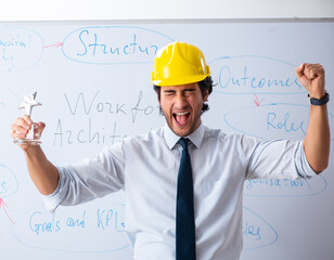 Young male architect in front of the whiteboard