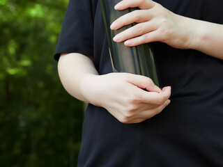 夏の公園の運動場で水筒を持つ中年主婦の姿