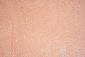 A wall with a tan color and a rough texture. The wall is empty and has no decoration