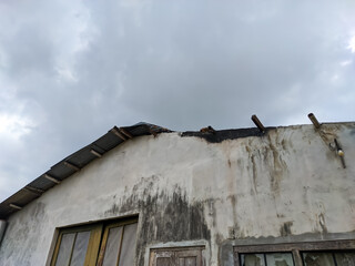 An evocative view of an old, weathered roof set against a brooding, overcast sky creates a sense of timelessness.