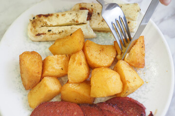 A Deliciously Prepared Plate of Roasted Potatoes Accompanied by Grilled Bananas, Rich in Flavor