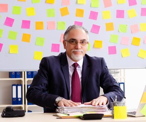 Aged man employee in conflicting priorities concept