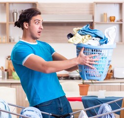 Young man husband doing clothing ironing at home