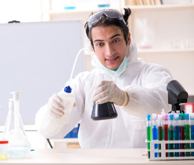 Naklejka premium Young handsome chemist working in the lab