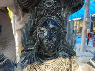 Fototapeta premium This image is from Balasore City, State Odisha Country India, Closeup of an Indian sculptor meticulously works on a stone statue face, polishing.