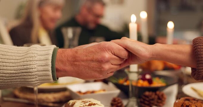 Hands, people and prayer with food for thanksgiving dinner, celebration and reunion on meal. Night, candles and family on dining table with grace for support, appreciate and unity to respect at home